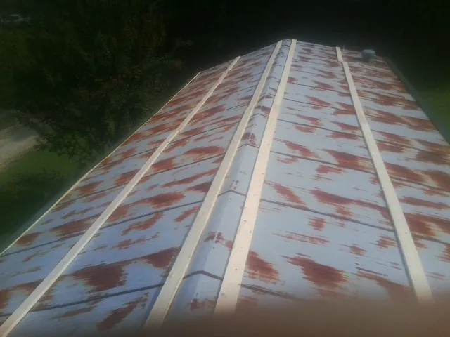 Rusted metal roof panels with new wood purlins before replacement — Storm Damage Roof Repair in Seaford by Roofing Brothers