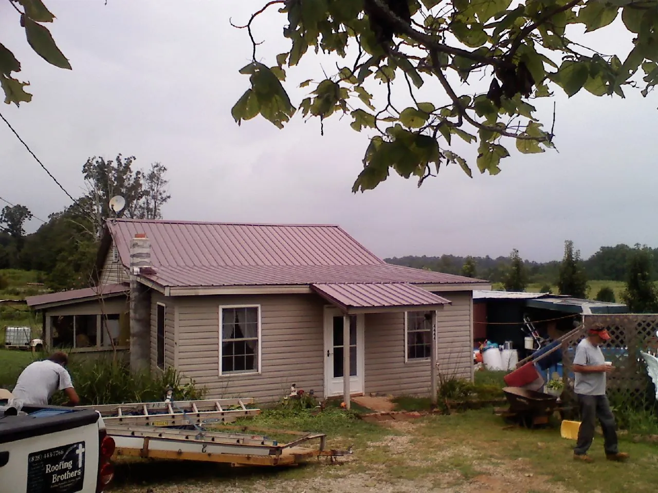 Crew finishing a mauve metal roof on a small farmhouse in Seaford